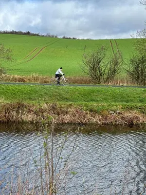 a man riding a bike on a path next to a body of water at Doralan in Bishopbriggs
