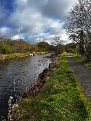 a river with a path next to a road at Doralan in Bishopbriggs