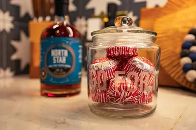 a jar of candy canes with a bottle of hot sauce at Stable Cottage, Gartocharn, Loch Lomond in Alexandria
