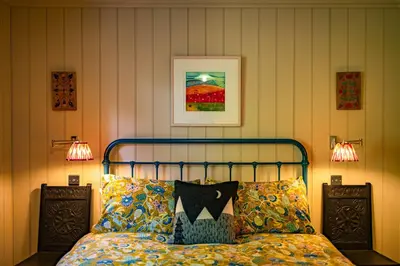 a bedroom with a bed with pillows and two lamps at Stable Cottage, Gartocharn, Loch Lomond in Alexandria