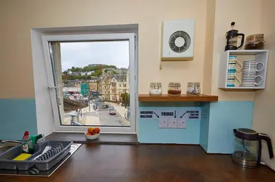 a kitchen with a window with a view of a street at Little Bay View in Oban