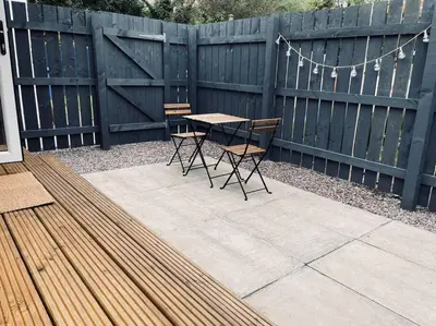 a patio with a table and chairs and a fence at West Highland Snug in Kinlochleven