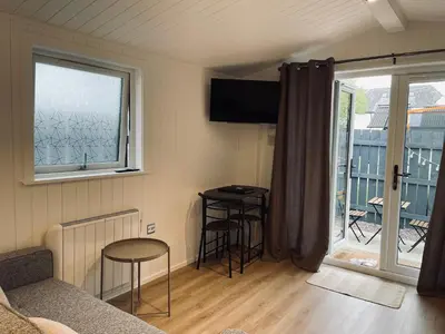 a living room with a couch and a table and a window at West Highland Snug in Kinlochleven