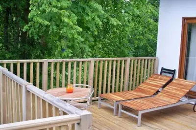 a porch with two benches and a table and a fence at Scottish Highland Cottage Tyndrum Upper Station in Crianlarich
