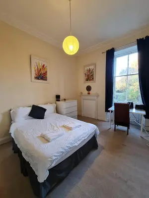 a bedroom with a large bed and a desk at Haymarket Station Rooms in Edinburgh