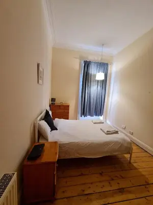 a bedroom with a large bed and a window at Haymarket Station Rooms in Edinburgh