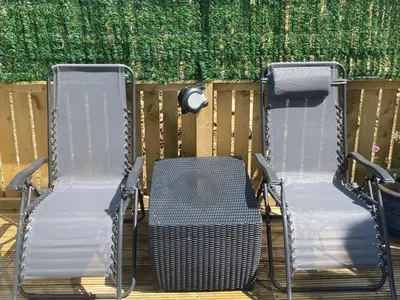 three chairs and a table and a fence at Lovely new caravan by Loch Long in Cove