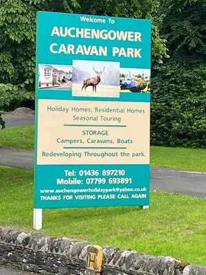 a sign for a caruana park with a sign in the grass at Lovely new caravan by Loch Long in Cove