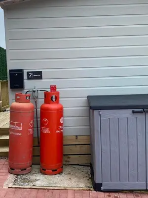 two red fire hydrants sitting next to a building at Lovely new caravan by Loch Long in Cove