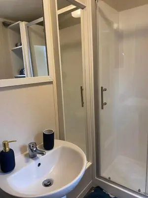 a bathroom with a white sink and a shower at Lovely new caravan by Loch Long in Cove