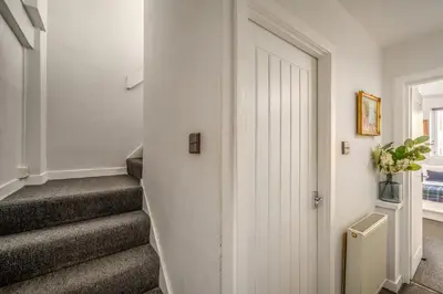a hallway with a white door and stairs at The Riverside Hideaway by Calton Living in Edinburgh
