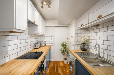 a kitchen with blue cabinets and a sink at The Riverside Hideaway by Calton Living in Edinburgh
