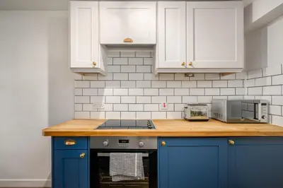 a kitchen with blue cabinets and a counter top at The Riverside Hideaway by Calton Living in Edinburgh