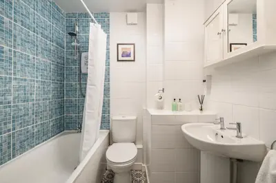 a bathroom with a toilet and a sink and a bath tub at The Riverside Hideaway by Calton Living in Edinburgh