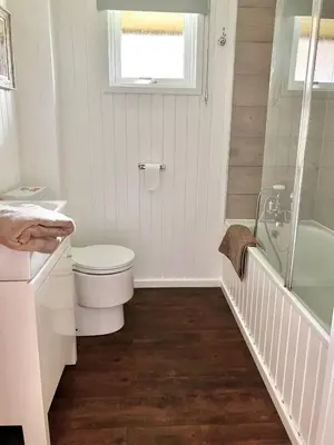 a white bathroom with a toilet and a shower at Stringy Rocks in Morenish