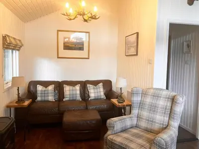 a living room with a couch and a chair at Stringy Rocks in Morenish