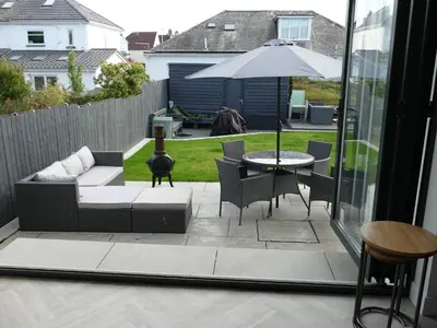 a patio with a couch and a table and an umbrella at The Annexe in Eaglesham