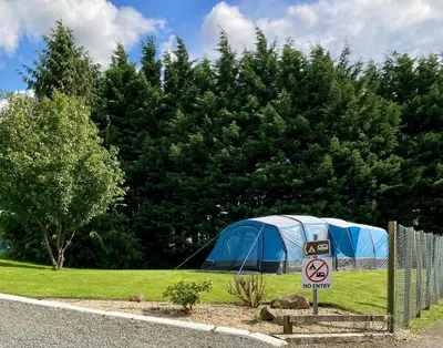 a blue tent in a field with trees at Red Deer Village Holiday Park - 3 Bedroom, Self-Catering Holiday Home in Steps