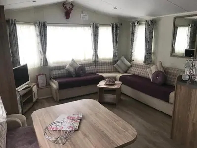 a living room with a couch and a table at Red Deer Village Holiday Park - 3 Bedroom, Self-Catering Holiday Home in Steps