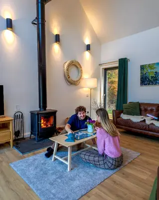 a boy and a girl sitting around a table in a living room at Forest Corner Luxury Home with Hot Tub in North Ballachulish