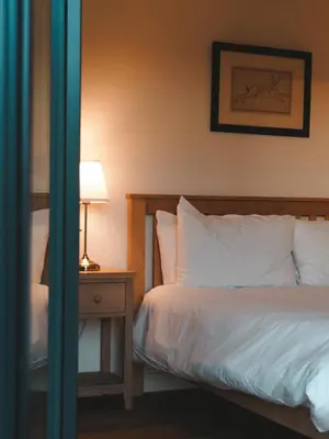 a bedroom with a bed and a table with a lamp at Forest Corner Luxury Home with Hot Tub in North Ballachulish