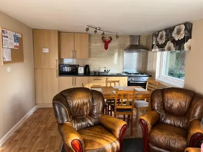 a kitchen and dining room with leather chairs and a table at Red Deer Village Holiday Park - 3 Bedroom, Self-Catering Chalet in Steps