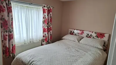a bedroom with a bed and a window with curtains at Red Deer Village Holiday Park - 3 Bedroom, Self-Catering Chalet in Steps
