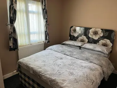 a bedroom with a bed with a flower head board at Red Deer Village Holiday Park - 3 Bedroom, Self-Catering Chalet in Steps