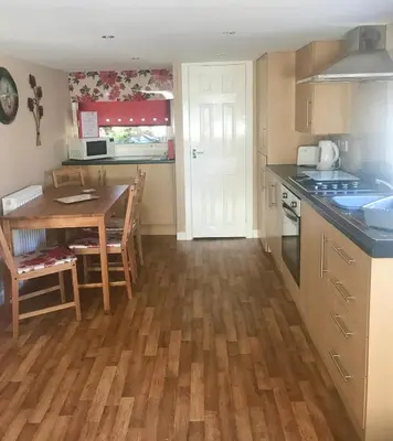a kitchen with a table and a dining room at Red Deer Village Holiday Park - 2 Bedroom, Self-Catering Chalet in Steps