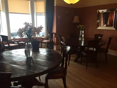 a dining room with tables and chairs and a vase of flowers at Broom Lodge in Largs