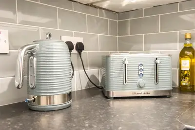 a toaster and coffee maker on a counter in a kitchen at Two Bed Stylish Apartment in Heart of West End in Glasgow