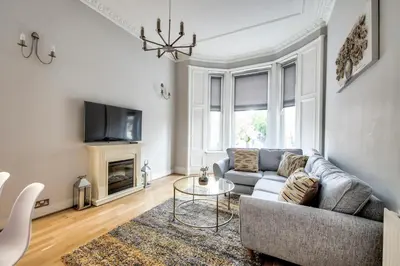 a living room with a couch and a table at Two Bed Stylish Apartment in Heart of West End in Glasgow