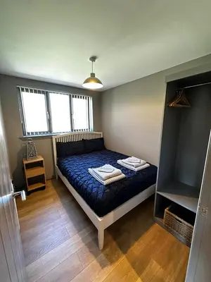 a bedroom with a bed with a blue comforter at Spacious 3-Bedroom Chalet on Country Estate near Glasgow - sleeps 6 in Glasgow