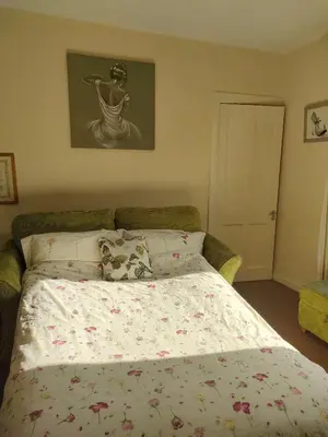 a bedroom with a bed with a flowered comforter at Forth Road Bridge Views in Queensferry