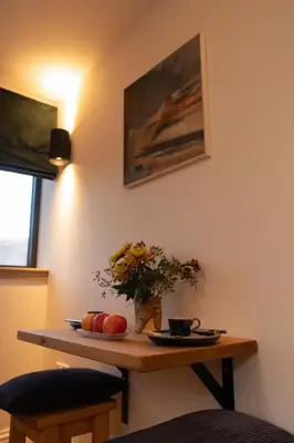 a table with apples and a vase of flowers on it at Forest Corner Luxury Apartment with Hot Tub in North Ballachulish
