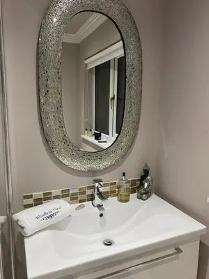 a bathroom with a white sink and a mirror at Woodhead view in Kirkintilloch