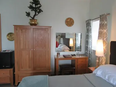 a bedroom with a bed and a dresser and a mirror at Middleton House Bed and Breakfast in Auchterarder