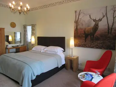 a bedroom with a bed and a picture of a deer on the wall at Middleton House Bed and Breakfast in Auchterarder