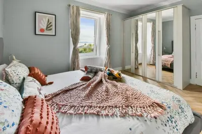 a bedroom with a bed with a rug on it at Seaside Place, Aberdour in Aberdour