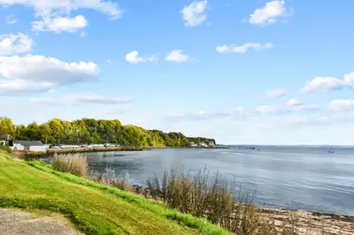a view of a body of water with trees at Blacksands Seaview Cottage, Aberdour in Aberdour