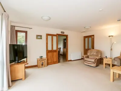 a living room with a flat screen tv and furniture at Cairnhapple House in Stranraer