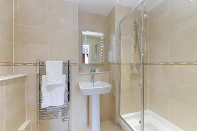 a bathroom with a sink and a shower and a toilet at Edinburgh City Suites in Edinburgh