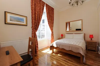 a bedroom with a bed and a window at Edinburgh City Suites in Edinburgh