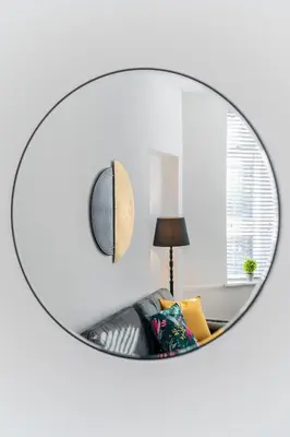 a mirror in a living room with a couch and a lamp at Dyke Apartment in Bailleston