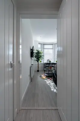 an open hallway with white walls and a room with a table at Dyke Apartment in Bailleston