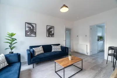 a living room with a blue couch and a table at Locksley House in Knightswood