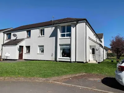 a white house with a dog in the window at Facing Glasgow Green spacious Apartment Free parking in Glasgow