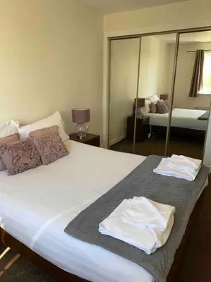 a bedroom with a large bed with two towels on it at Facing Glasgow Green spacious Apartment Free parking in Glasgow