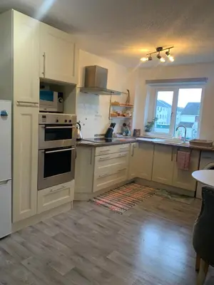a large kitchen with white cabinets and a window at Facing Glasgow Green spacious Apartment Free parking in Glasgow