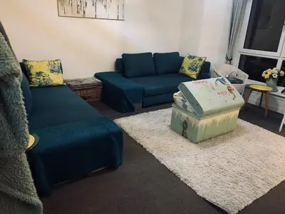 a living room with a blue couch and a ottoman at Facing Glasgow Green spacious Apartment Free parking in Glasgow